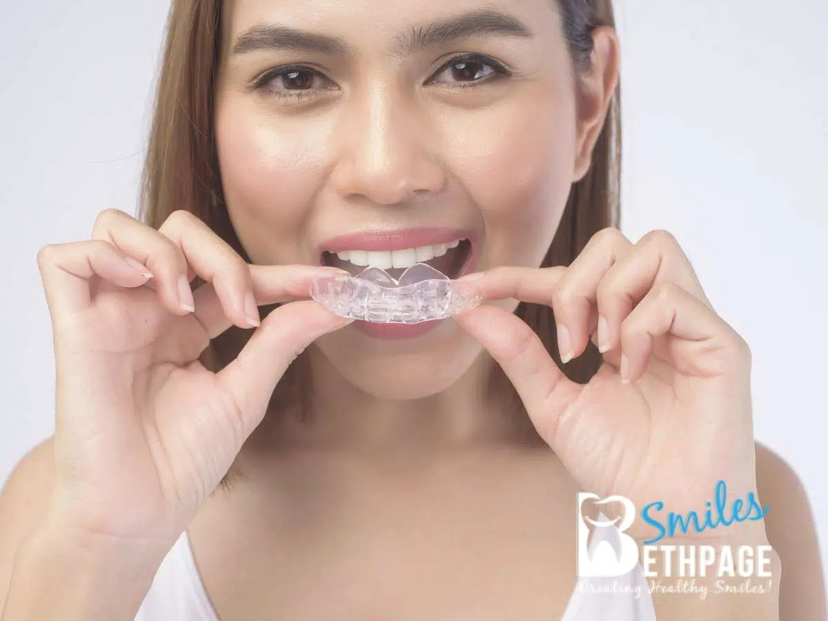 A beautiful woman using her invisalign treatment in Bethpage, NY.